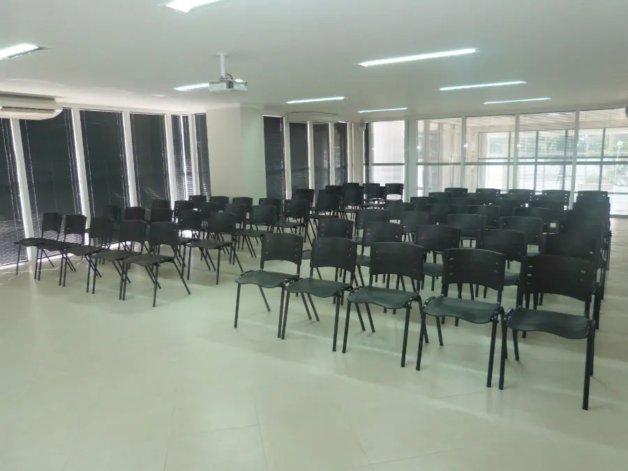 Auditório Sol Poente montado com cadeiras em fileiras e projetor