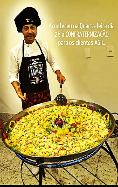 Chef com a paella de frutos do mar na confraternização de 2018